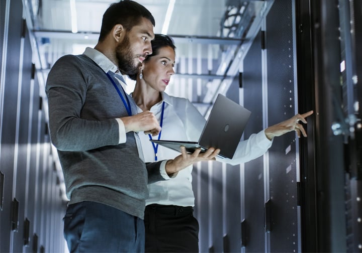 A man and a woman look at a high tech digital screen