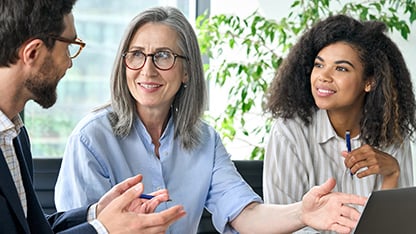 Three people in a professional team engaged in discussion