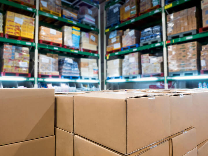 group of boxes in a warehouse with shelves full of retail goods on pallets