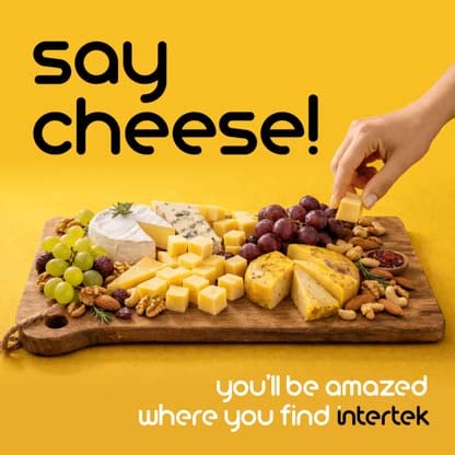 A wooden serving board filled with cheese, fruit and nuts